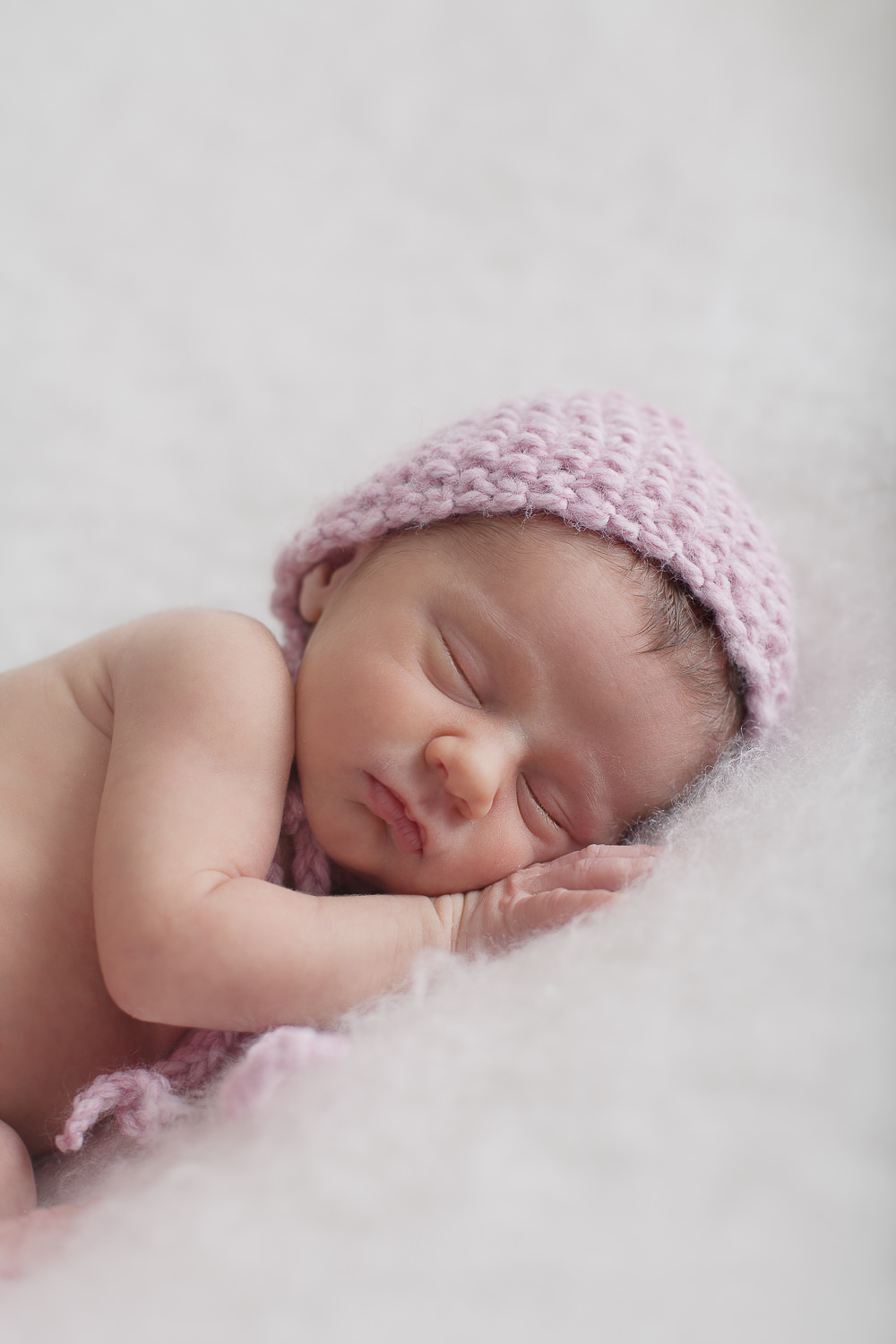 bébé qui dort avec un bonnet rose